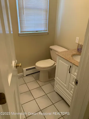 a white toilet sitting next to a white sink and vanity