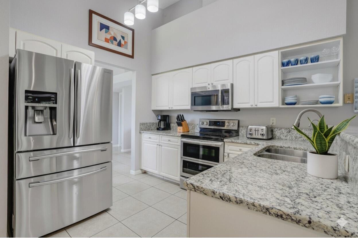 13218 86th Road North The Acreage, FL 33412 - Photo 24 of 69 a kitchen with stainless steel appliances granite countertop a refrigerator sink and stove