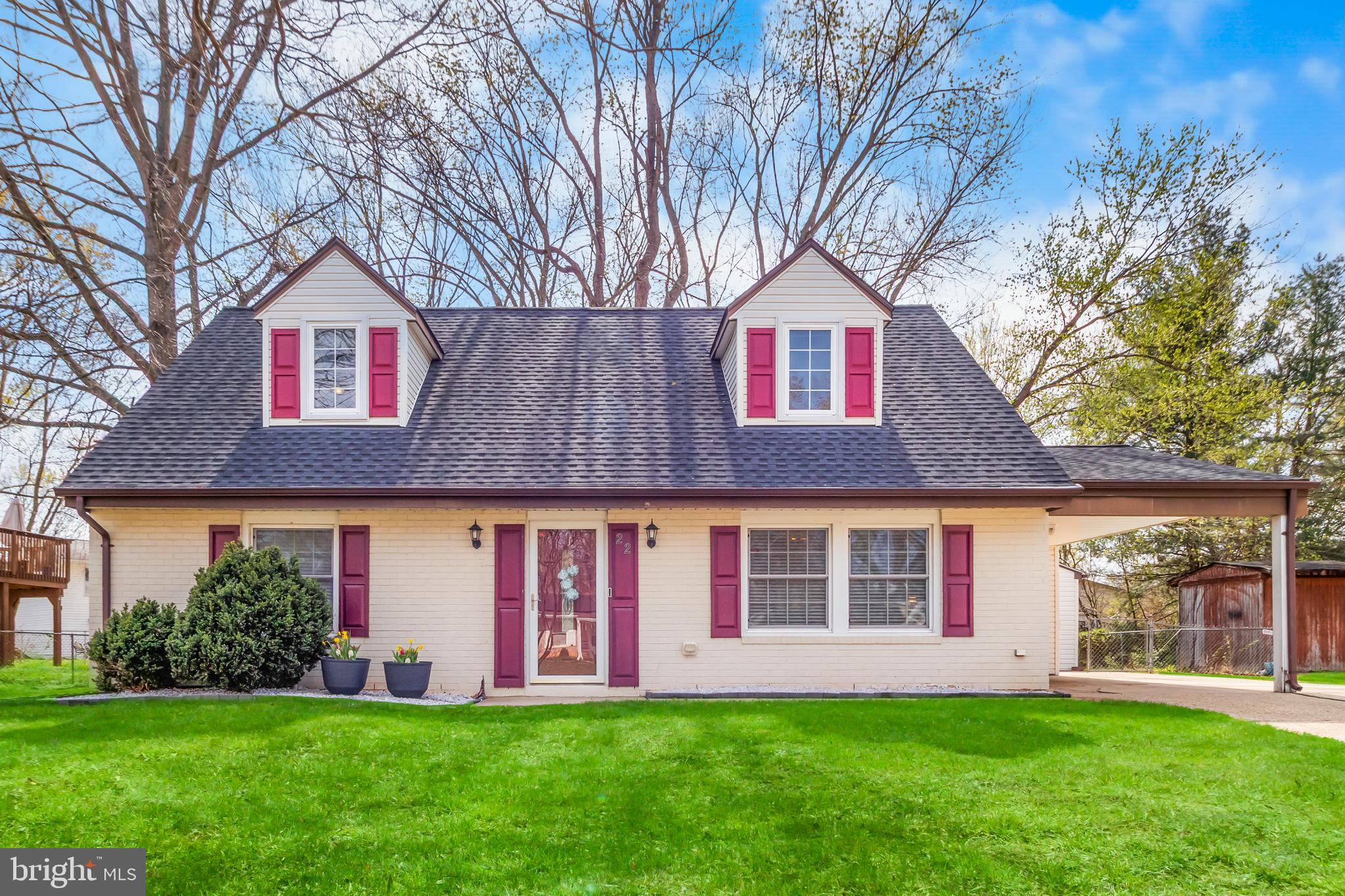 a front view of a house with a yard and trees