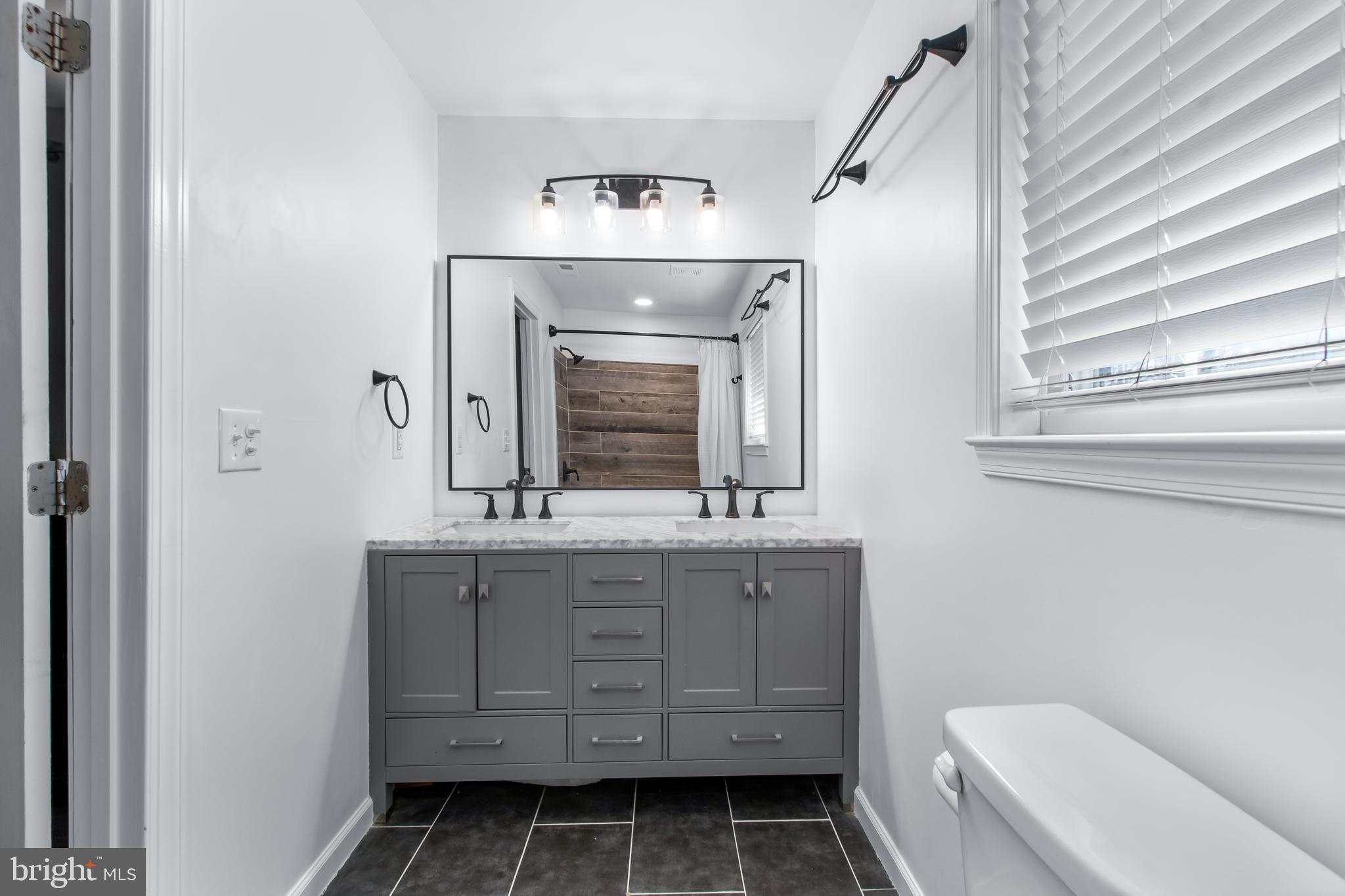 22 Marshall Road Waldorf, MD 20602 - Photo 19 of 38 a bathroom with a granite countertop toilet a sink and a mirror