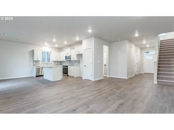 a room with stainless steel appliances kitchen island sink refrigerator and window