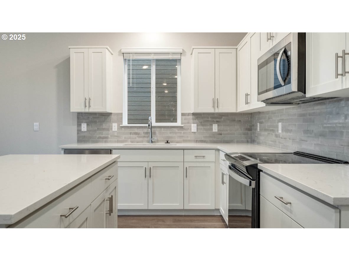 9463 Southeast Crystal Rose Street Happy Valley, OR 97086 - Photo 10 of 27 a kitchen with a sink stove and cabinets