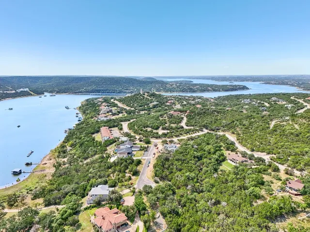 an aerial view of residential houses with outdoor space and trees