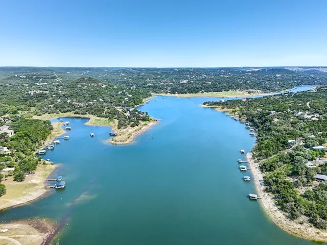an aerial view of ocean and residential houses with outdoor space