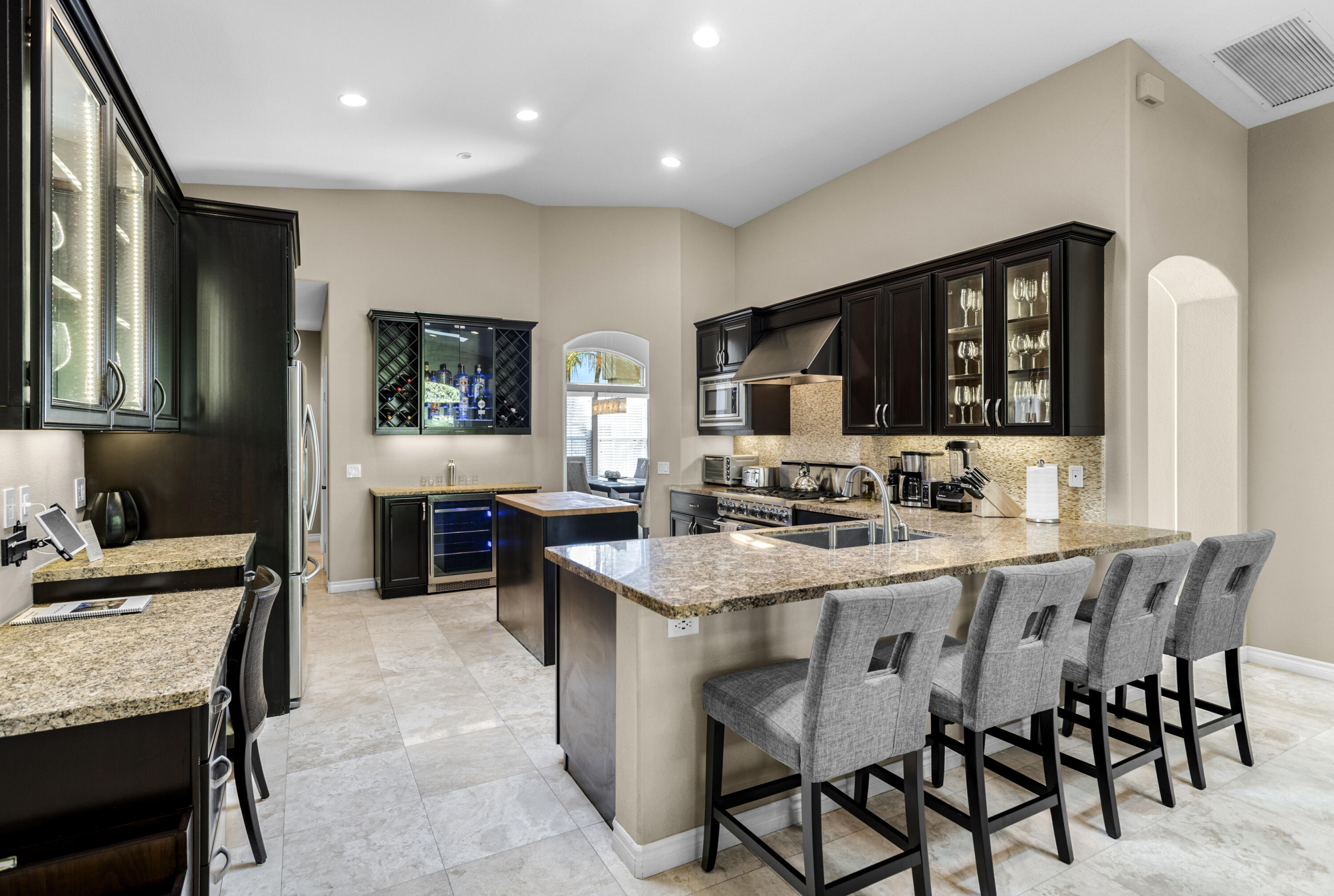 68590 Risueno Road Cathedral City, CA 92234 - Photo 9 of 72 a kitchen with stainless steel appliances kitchen island granite countertop a sink a stove a dining table and chairs