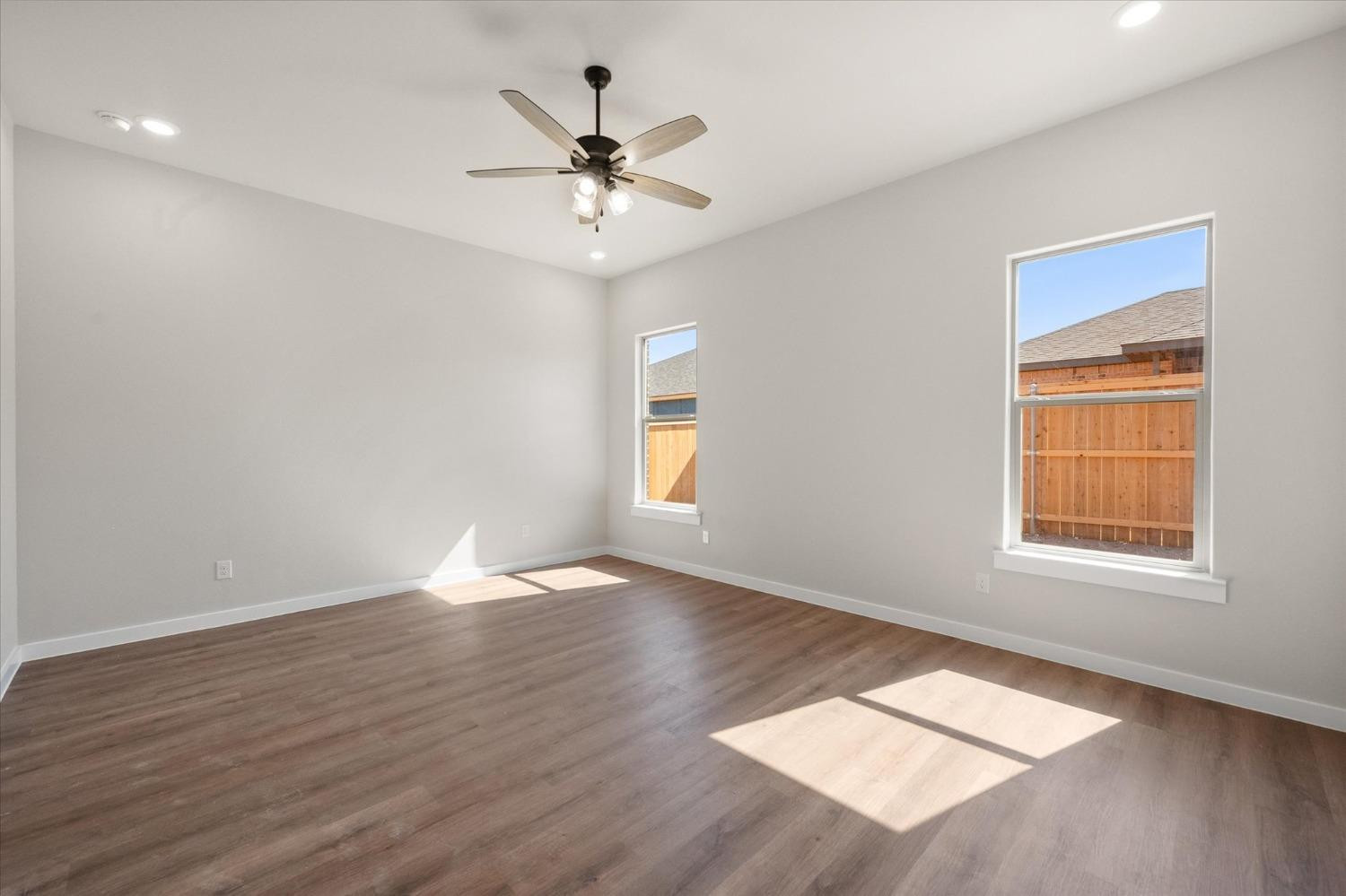 6917 55th Street Lubbock, TX 79407 - Photo 11 of 20 a view of an empty room with wooden floor and a window