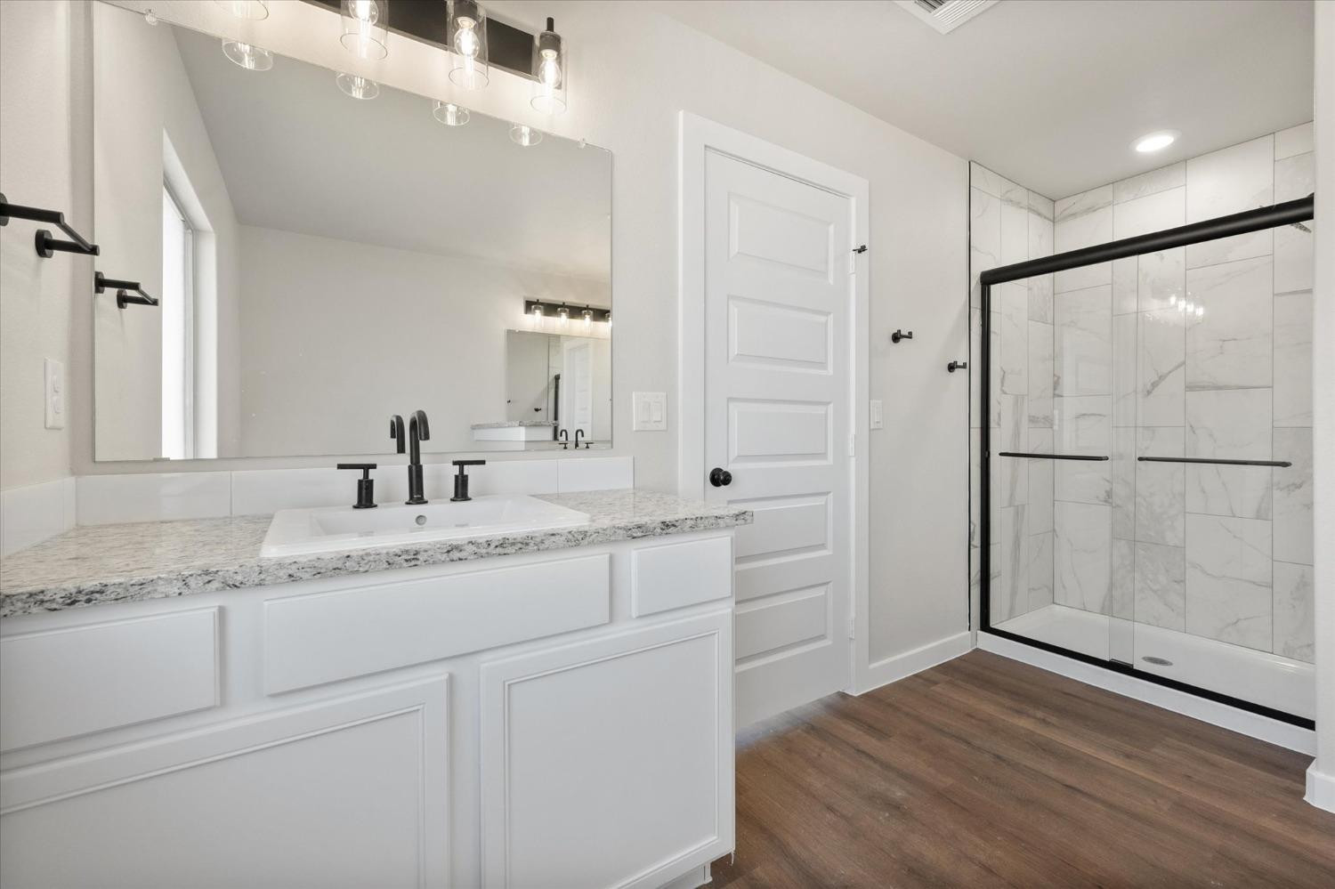6917 55th Street Lubbock, TX 79407 - Photo 13 of 20 a bathroom with a granite countertop sink mirror and shower