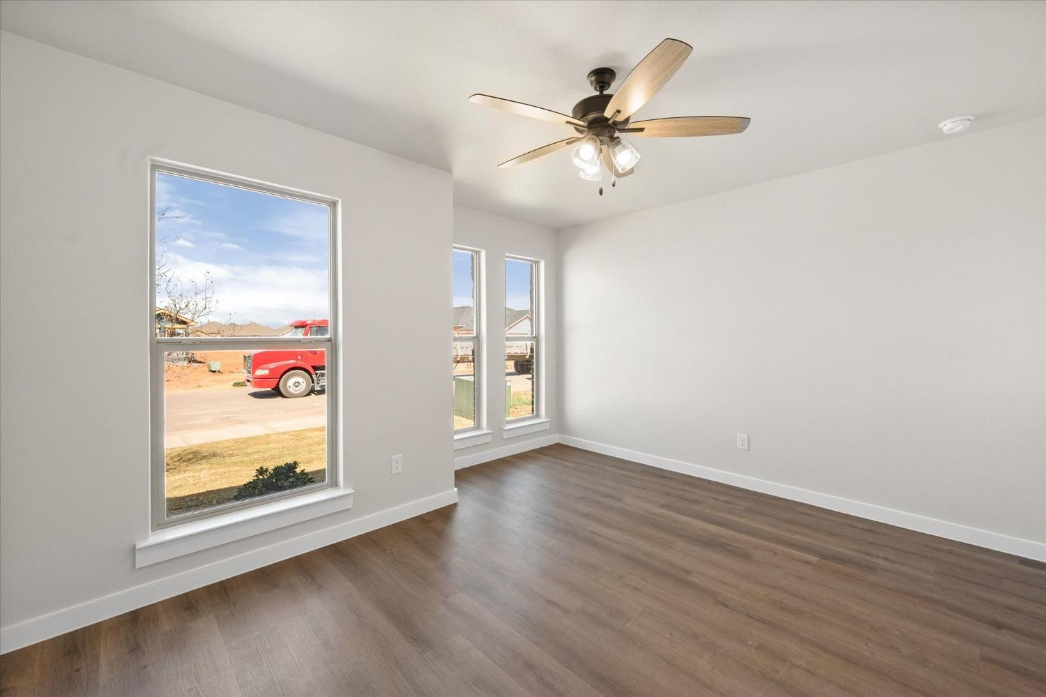6917 55th Street Lubbock, TX 79407 - Photo 16 of 20 a view of an empty room with wooden floor and a window