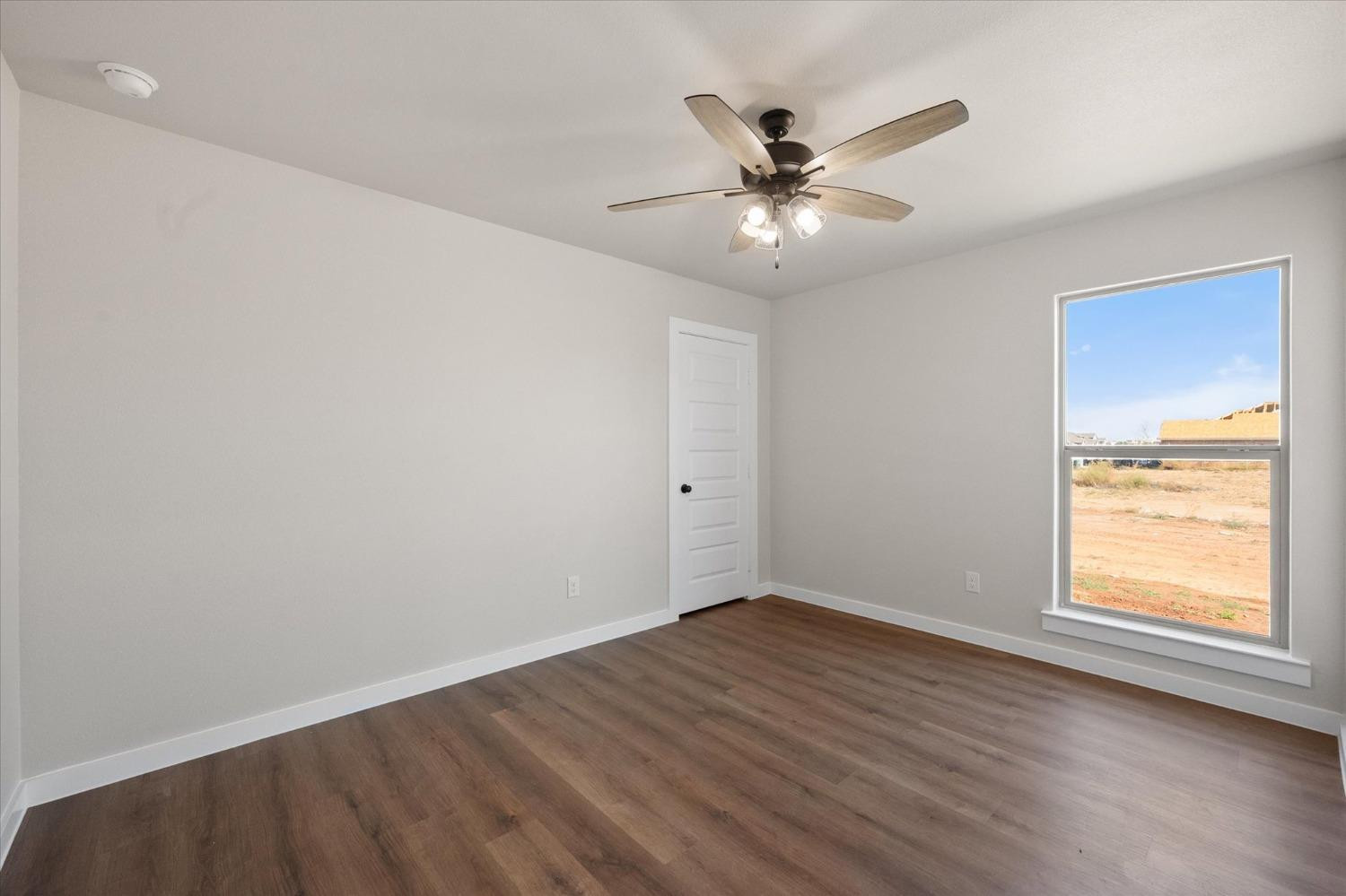 6917 55th Street Lubbock, TX 79407 - Photo 17 of 20 a view of an empty room with wooden floor and a window