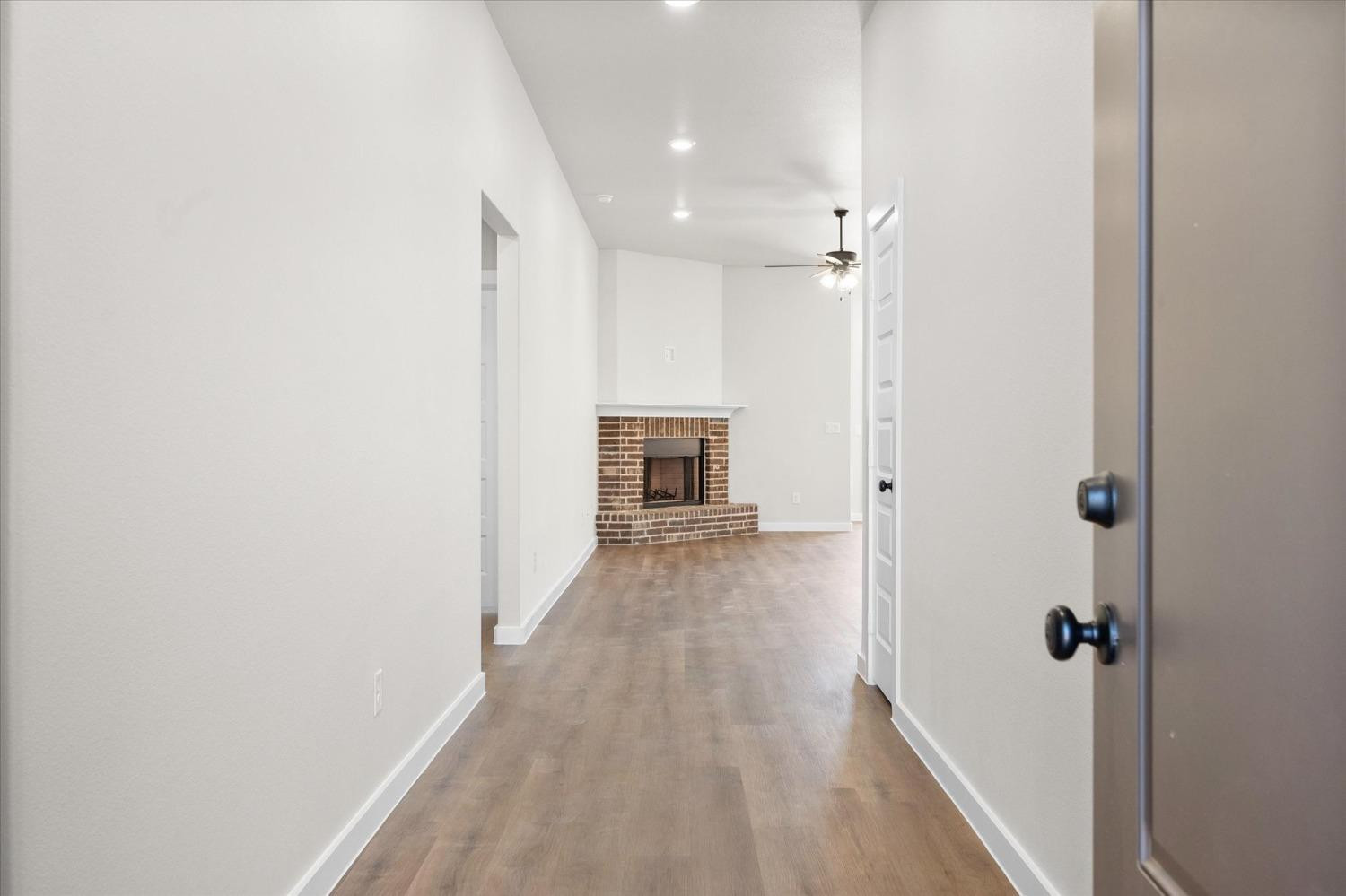 6917 55th Street Lubbock, TX 79407 - Photo 2 of 20 a view of a hallway with wooden floor and a bathroom