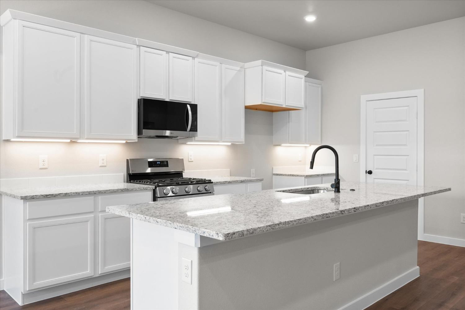 6917 55th Street Lubbock, TX 79407 - Photo 6 of 20 a kitchen with sink a microwave and cabinets