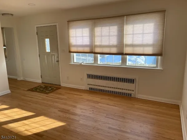 a view of a room with wooden floor and windows
