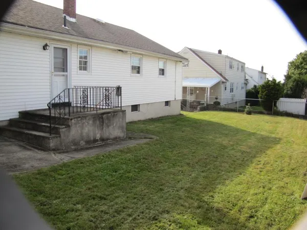 a view of a house with a yard and sitting area