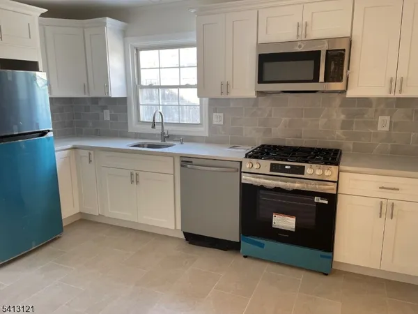 a kitchen with cabinets stainless steel appliances and a sink