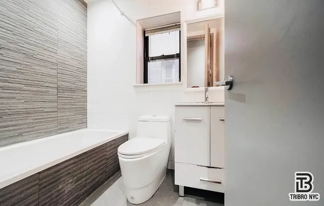 a bathroom with a toilet sink and mirror