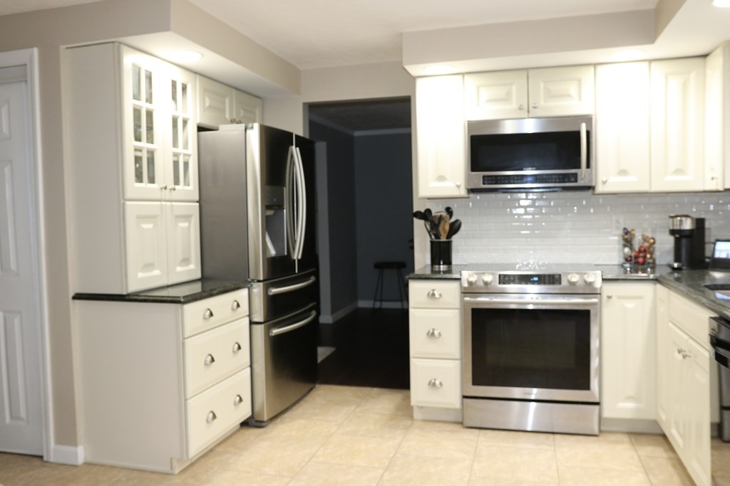 28 South Meadow Road Clinton, MA 01510 - Photo 8 of 24 a kitchen with stainless steel appliances a stove a microwave and a refrigerator