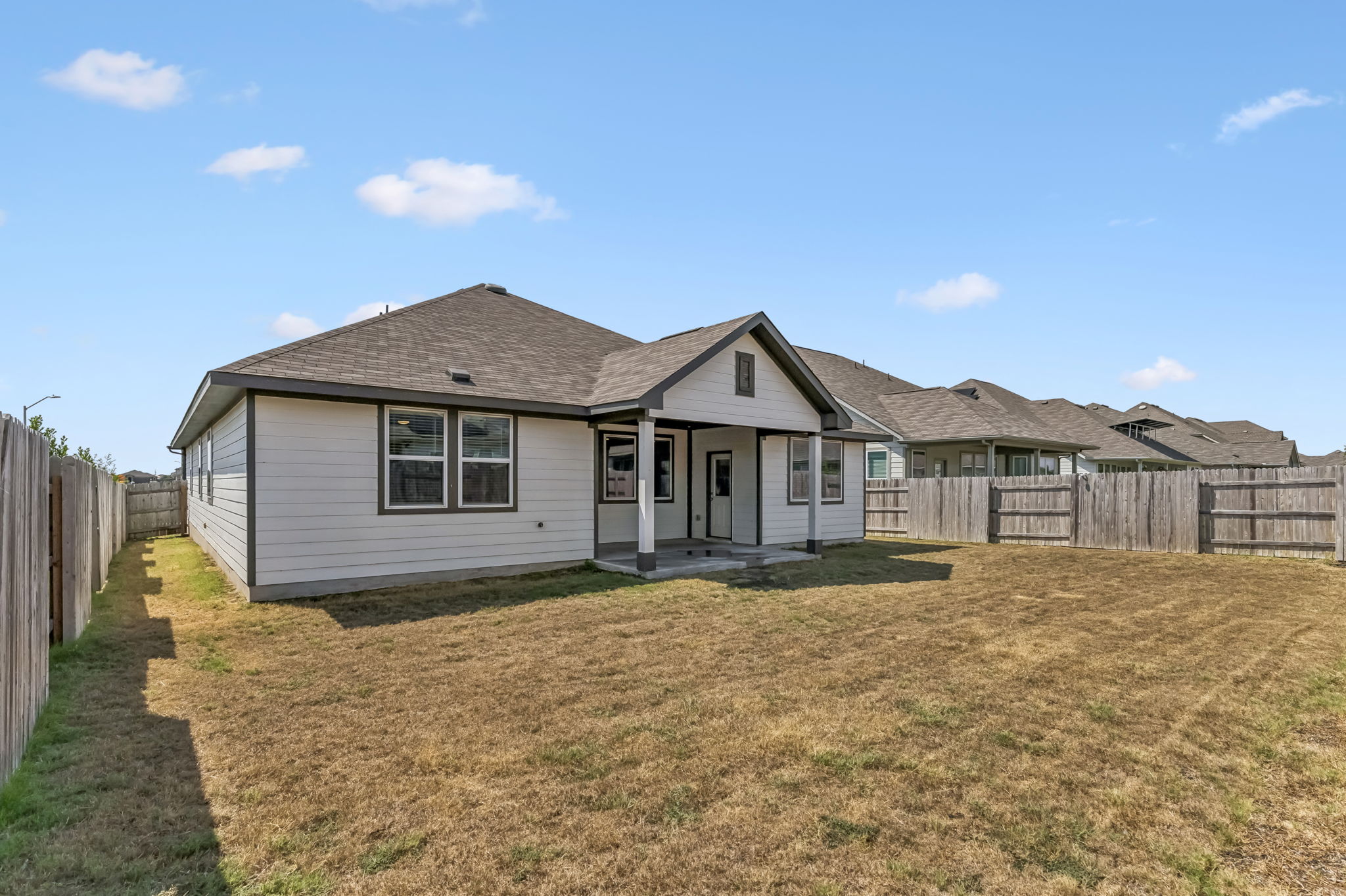 4009 Milano River Road Hutto, TX 78634 - Photo 36 of 40 A spacious fully fenced backyard features a covered patio perfect for outdoor relaxation.