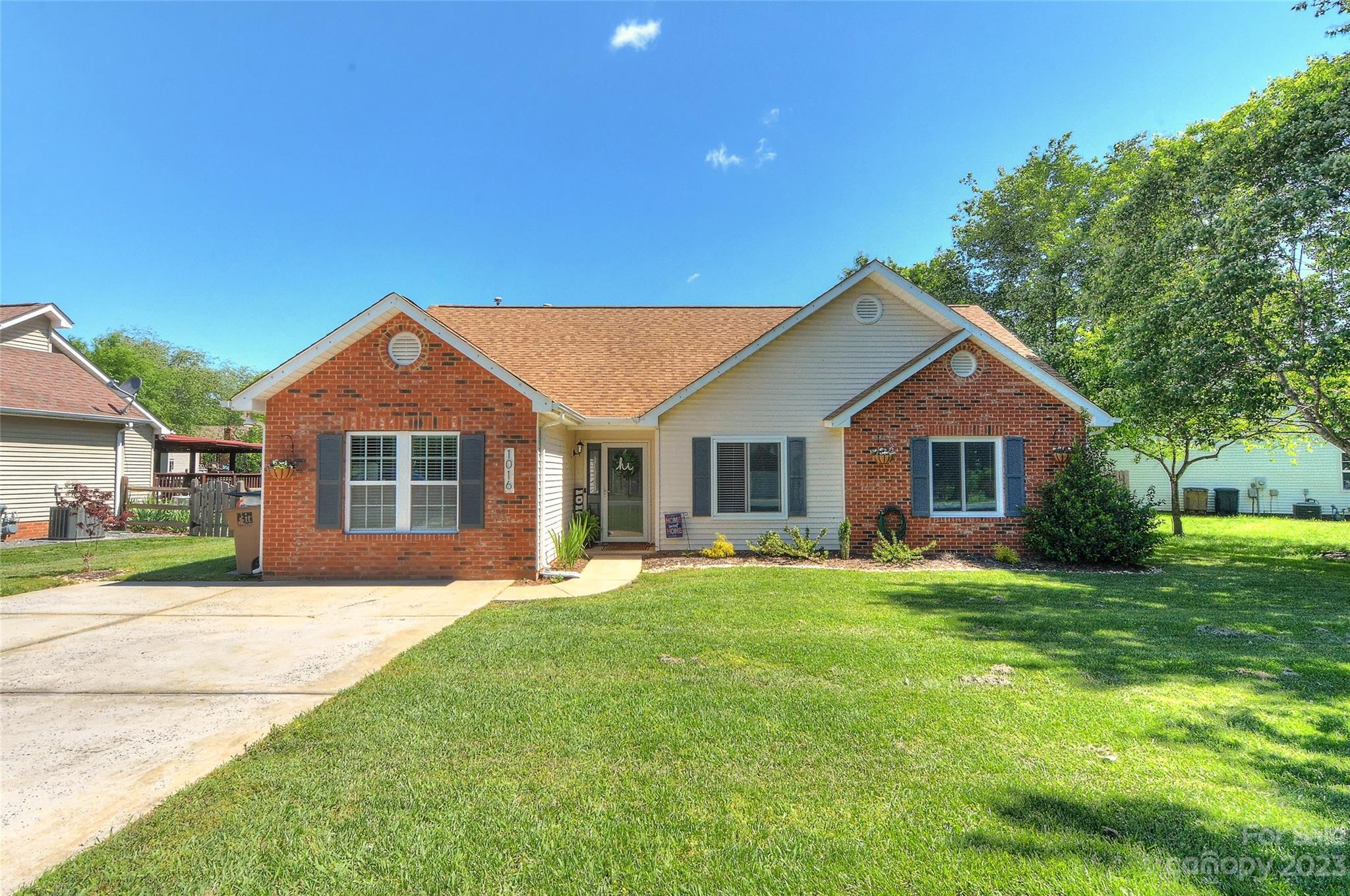 a front view of a house with a yard and trees