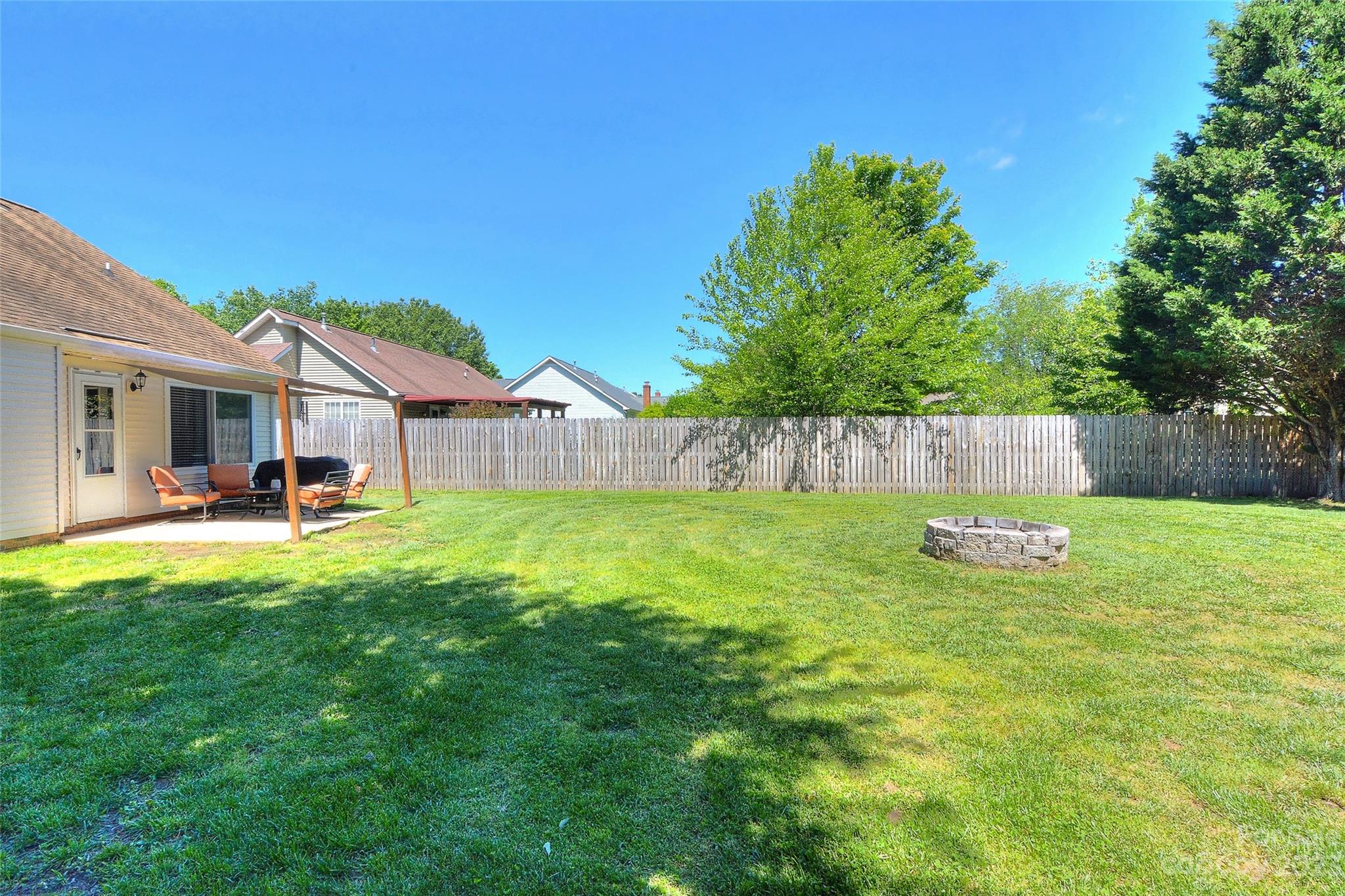 1016 Ridgefield Circle Indian Trail, NC 28079 - Photo 18 of 19 a view of a backyard with table and chairs and wooden fence