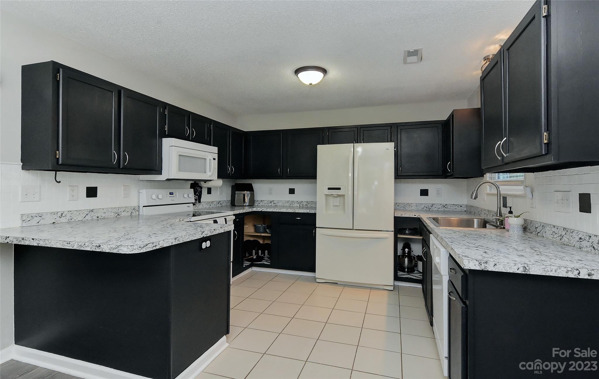 1016 Ridgefield Circle Indian Trail, NC 28079 - Photo 4 of 19 a kitchen with a sink stove a refrigerator and a microwave