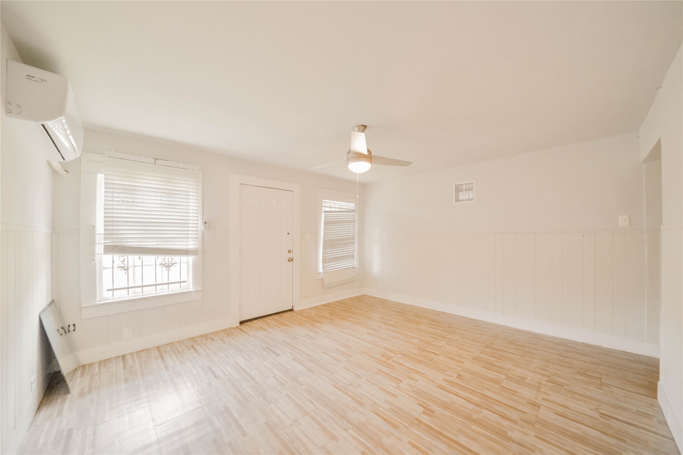 5101 Crane Street, Unit 2 Houston, TX 77026 - Photo 3 of 6 an empty room with wooden floor and windows