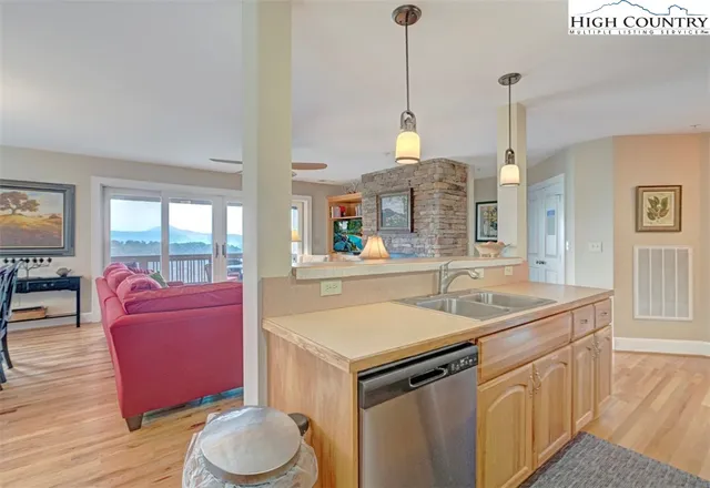 a kitchen with a sink stove and living room