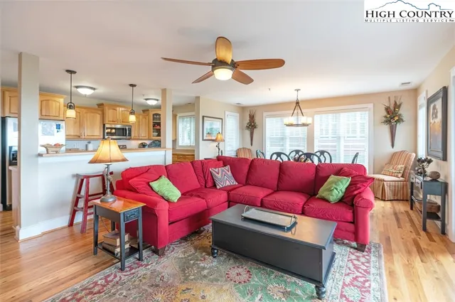 a living room with furniture kitchen view and a large window