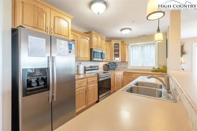 a kitchen with granite countertop a refrigerator and a sink
