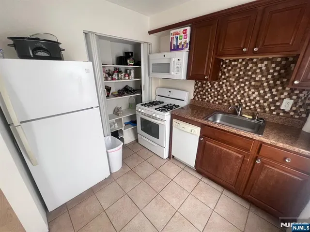 a white refrigerator freezer and a stove sitting inside of a kitchen