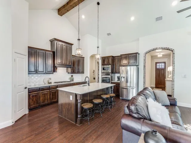 a living room with furniture kitchen view and a chandelier