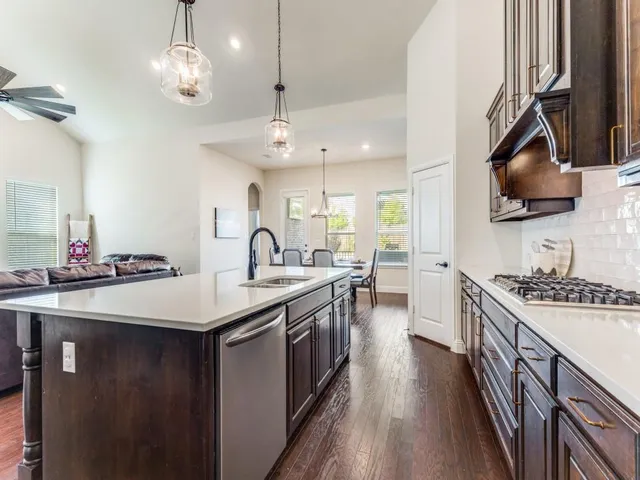 a kitchen with stainless steel appliances granite countertop a sink and stove top oven