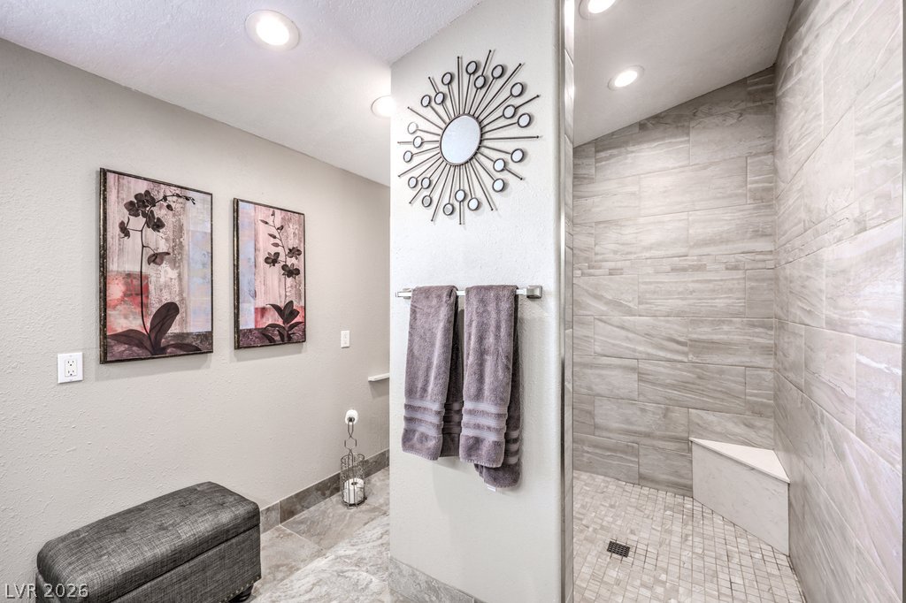 4375 Pinwheel Street Logandale, NV 89021 - Photo 24 of 52 Tiled shower with a corner seat offers a refreshing and sleek bathing experience.