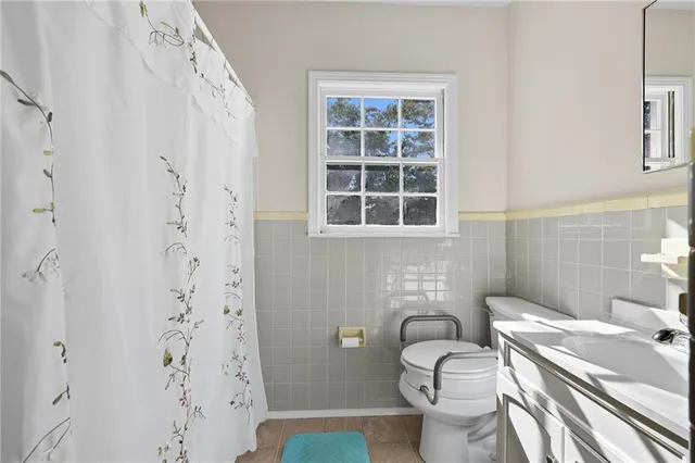 a bedroom with a bed and a dresser next to a window