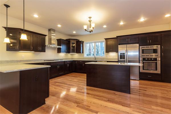 a kitchen with stainless steel appliances kitchen island granite countertop a stove kitchen island a sink dishwasher a refrigerator and a oven with wooden floor