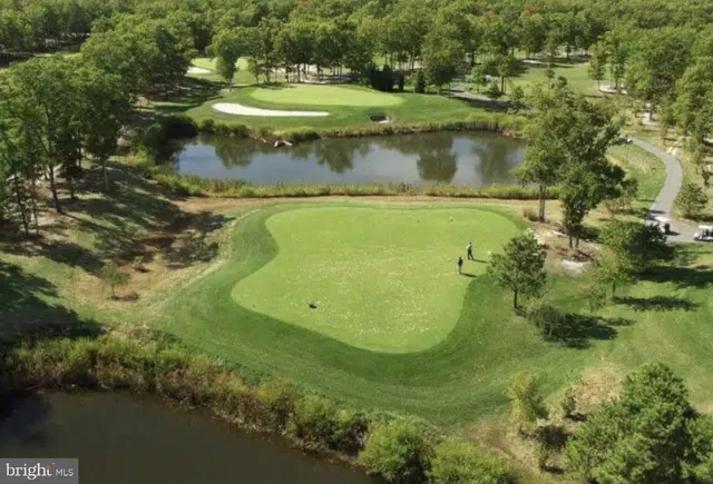 a view of a water pond with green yard