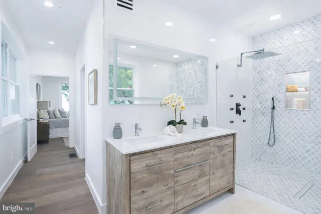 a bathroom with a sink double vanity mirror and a bathtub