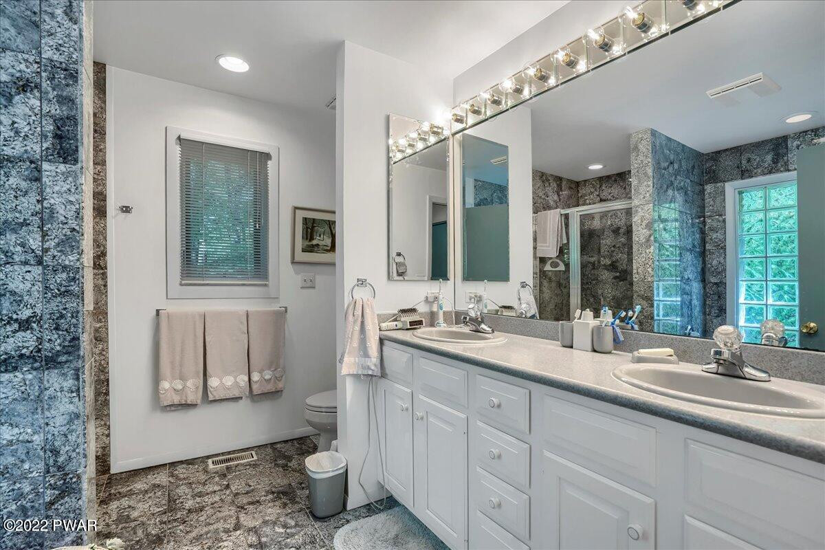 110 Ridge Road Hawley, PA 18428 - Photo 18 of 49 a bathroom with a sink double vanity and a toilet