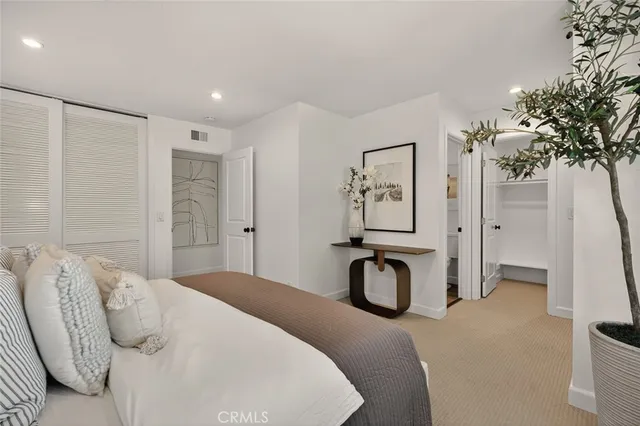 a bedroom with a bed and a potted plant