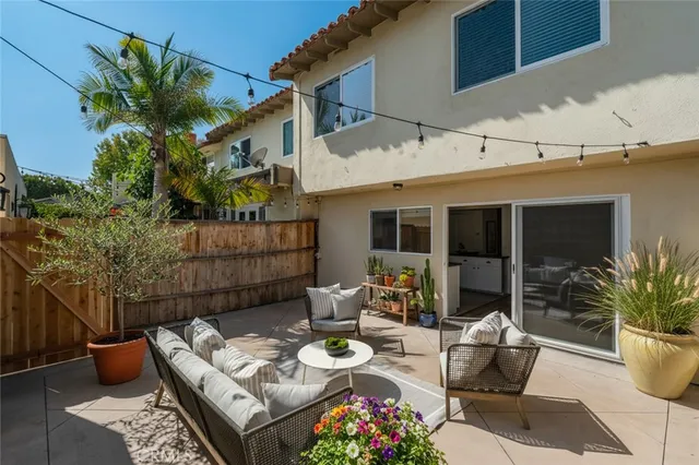 a view of a patio with couches table and chairs and potted plants