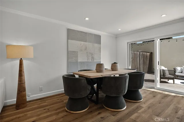 a dining room with wooden floor a glass table and chairs