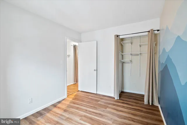 a view of a room with wooden floor and a bathroom