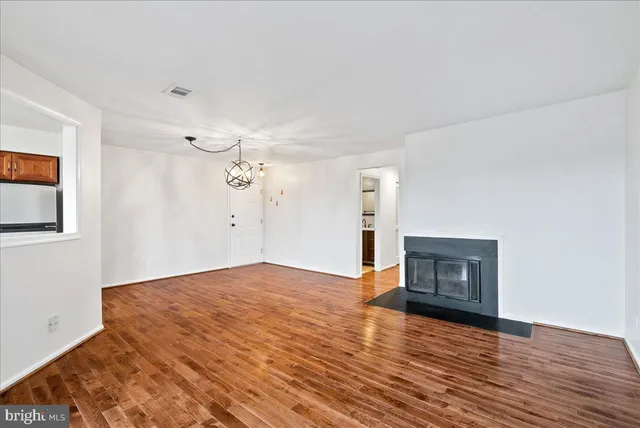 a view of empty room with wooden floor and fireplace