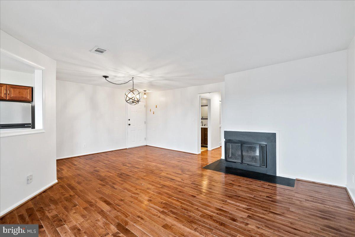 11146 Beaver Trail Court Reston, VA 20191 - Photo 4 of 17 a view of empty room with wooden floor and fireplace