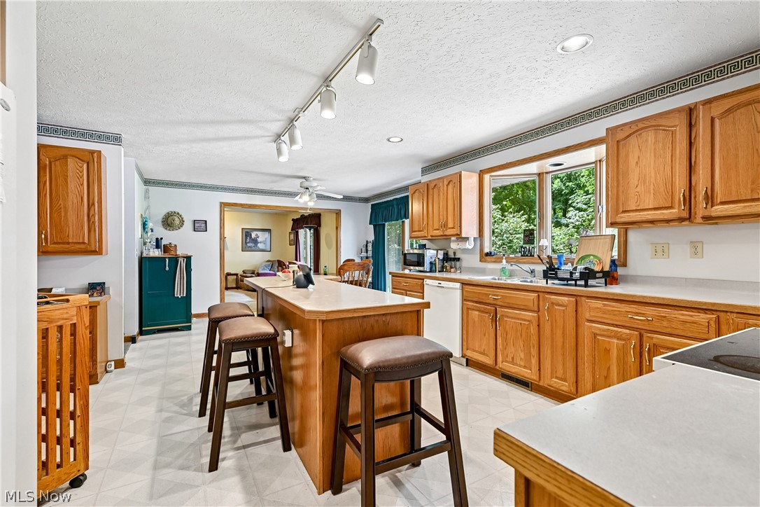 2660 South Medina Line Road Wadsworth, OH 44281 - Photo 13 of 48 Expansive eat-in kitchen featuring a center island with breakfast bar, sink, appliances, wood cabinetry, plenty of counterspace, recessed & track lighting, and LVT flooring