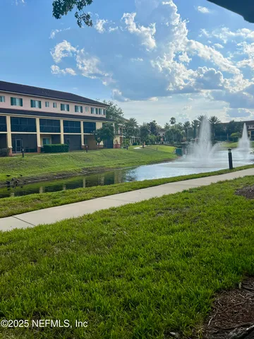 an aerial view of a multi story residential apartment building with a yard and sitting area