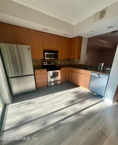 a kitchen with stainless steel appliances granite countertop a refrigerator sink and stove