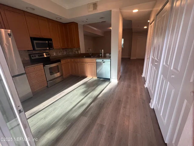 a kitchen with sink a microwave a refrigerator and cabinets