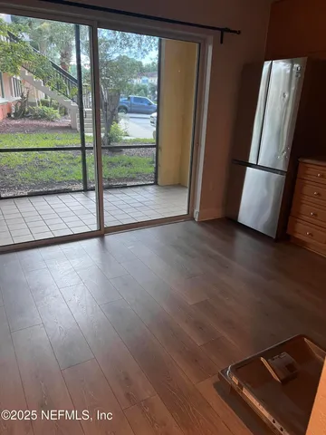 a view of an empty room with wooden floor and a chair