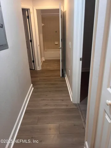 a view of a hallway with wooden floor and staircase