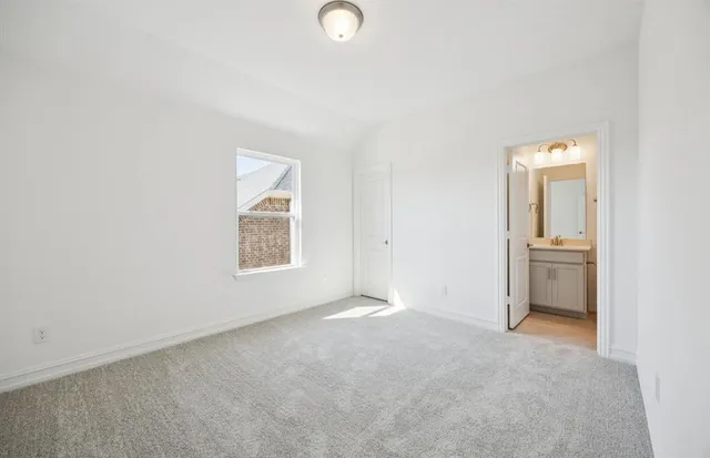 an empty room with a bathroom and a window